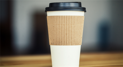Generic image of a white disposable coffee cup with blurred background