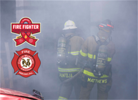 Two firefighters in gear move through dense smoke. Badges for 