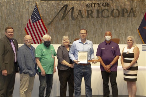 A group of people stands in front of a 