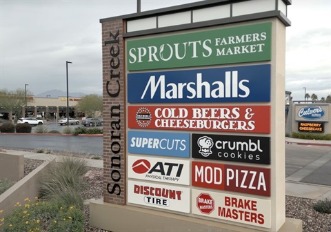 Shopping center sign at Sonoran Creek displays store logos: Sprouts, Marshalls, Cold Beers & Cheeseburgers, Supercuts, Crumbl, ATI, Mod Pizza, Discount Tire, Brake Masters.