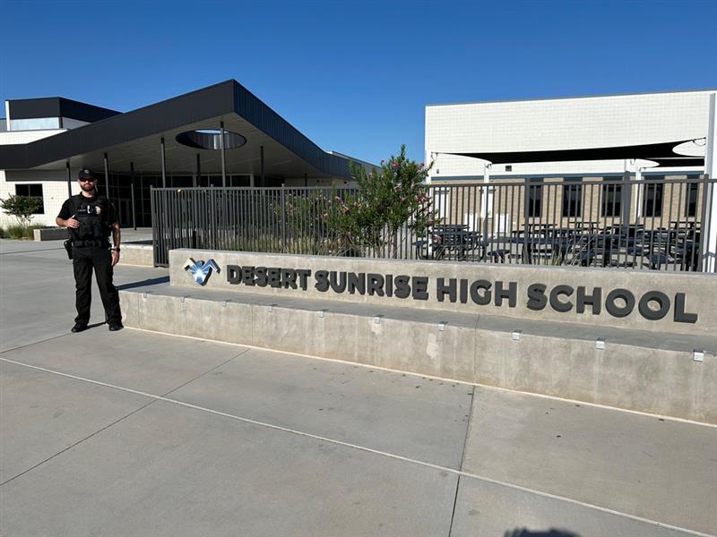 A person in uniform stands beside a sign reading 