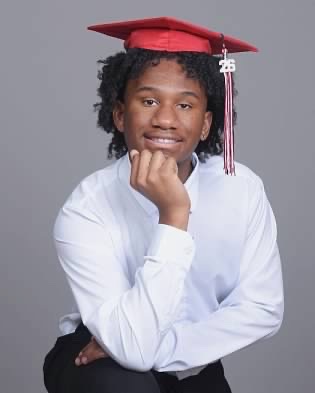 Young man smiling, wearing a red graduation cap with a 