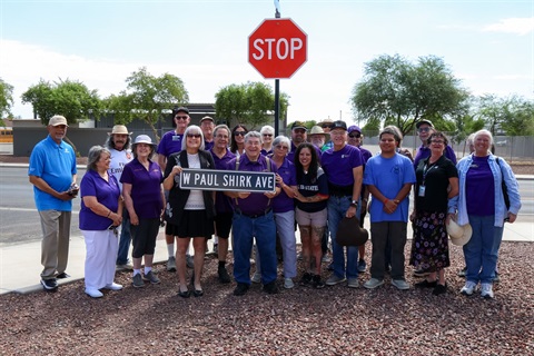 Group of Maricopa Historical Society members and Maricopa City Council gathered holding the W Paul Shirk Ave street sign.
